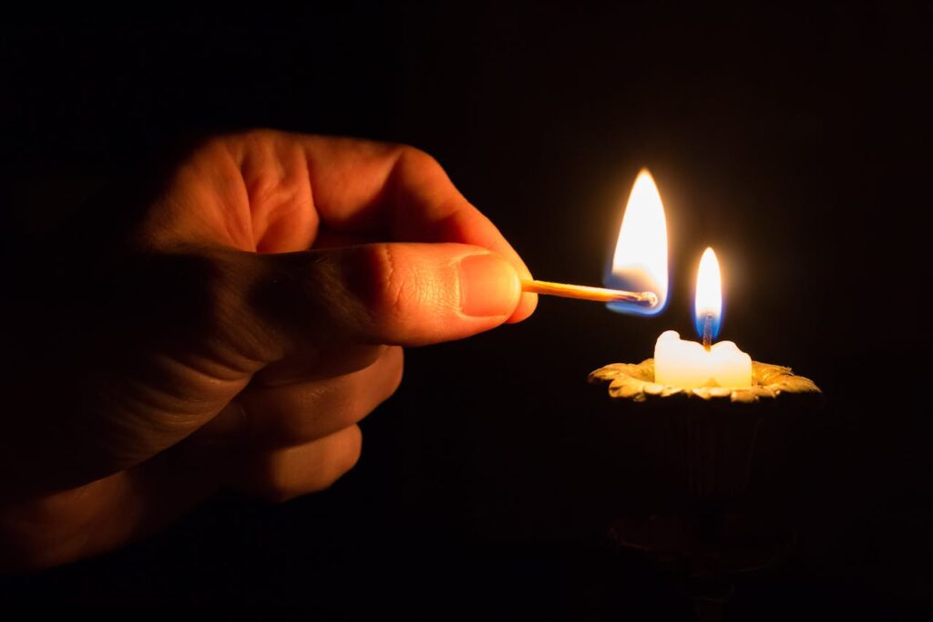 Pessoa Segurando Um Palito De Fósforo Com Fogo Na Frente De Uma Vela Com Fogo